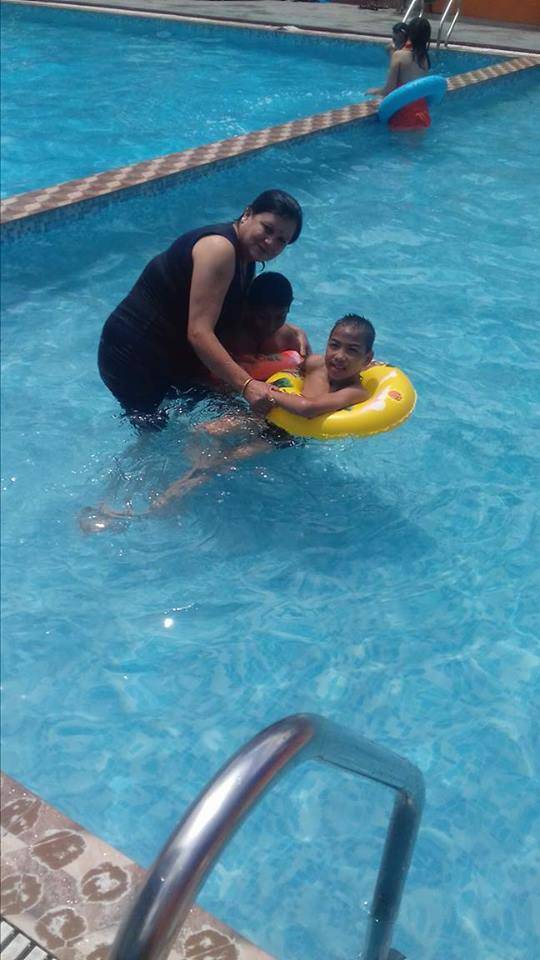 A teacher helping a student to swim