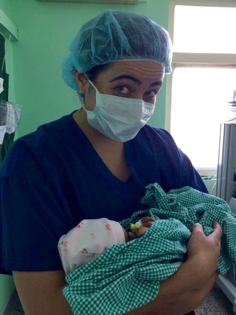 A medical volunteer holding a young baby 